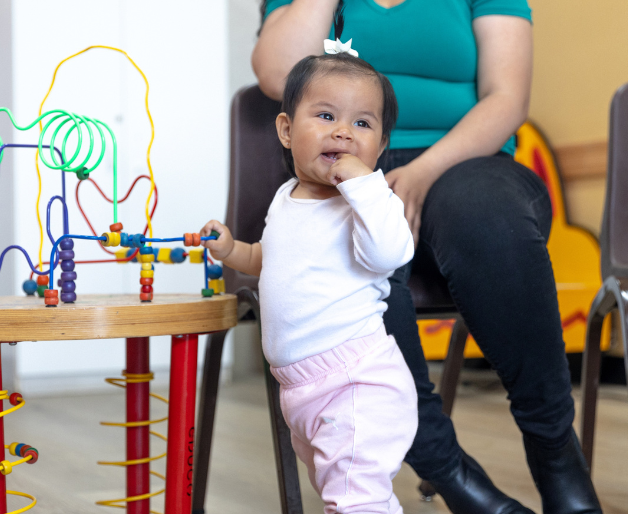 Toddler standing next to mother